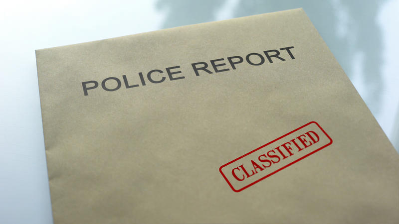 Police report classified, seal stamped on folder with important documents