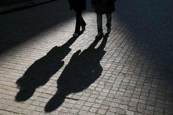 Close-up of the shadows of two people on the ground.